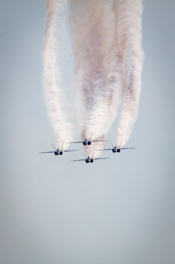 Vertical shot of the military aircrafts in the air emitting smoke during the air show
